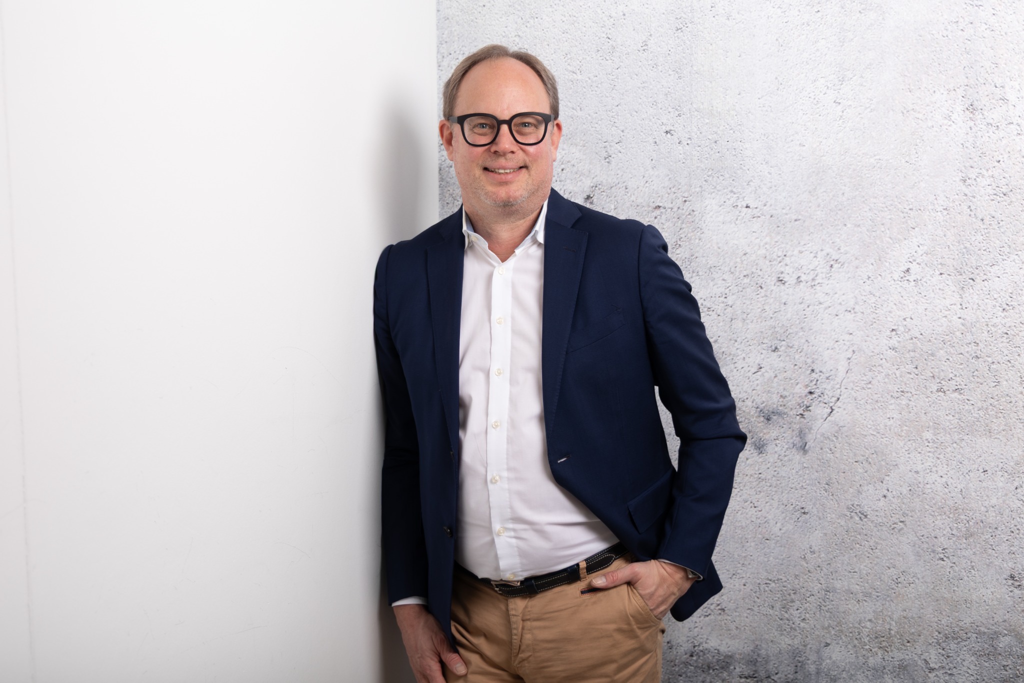Christian Butz, BeEnergetic, im Business-Portrait an einer Betonwand